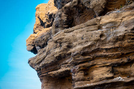 a rock with many holes eroded by the sea wavesの写真素材
