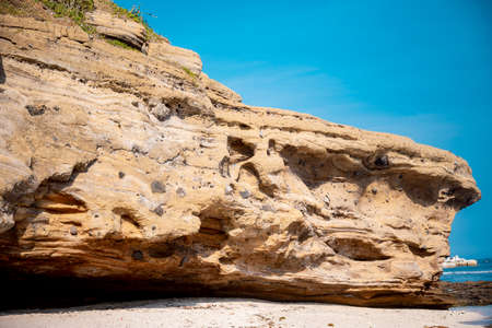 Natural background. Closeup edged shabby cliff cracks. Gray-brown stone rock texture of mountains....