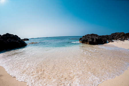 Beautiful beach with turquoise water and rocks on a sunny dayの写真素材