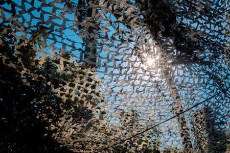 A low angle shot of a metal structure with the sun shining through itの写真素材