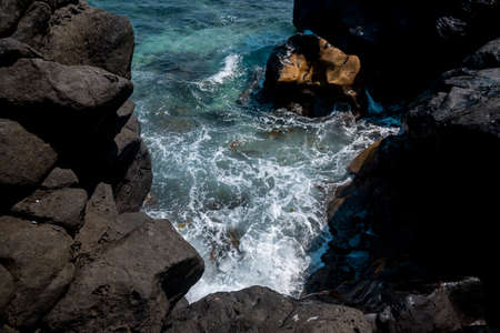 Black lava rocks with turquoise sea water on the island of Lanzaroteの写真素材
