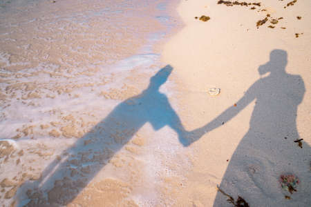 Silhouette of a man and a woman on the beach.の写真素材