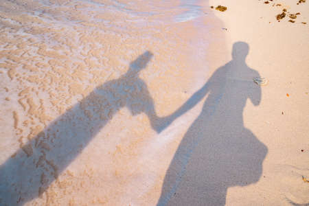 Silhouette of a man and a woman on the beach.の写真素材