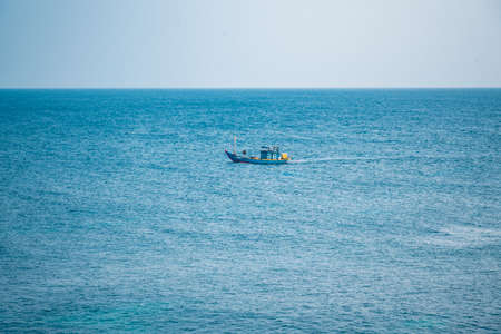 Small fishing boat in the sea. Blue sea and blue sky.の写真素材