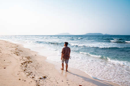 Man walking on the beach in the morning. Summer vacation concept.の写真素材