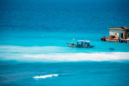 Cargo ships on the roads, coastline. Bright blue sky, sunny day.