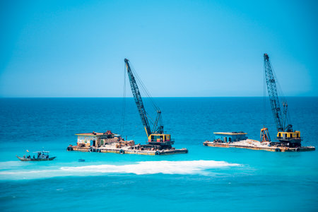 Cargo ships on the roads, coastline. Bright blue sky, sunny day.のeditorial素材