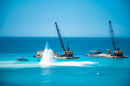 Cargo ships on the roads, coastline. Bright blue sky, sunny day.のeditorial素材