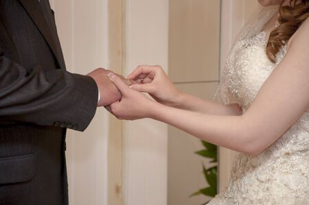 The bride puts on a wedding ring to the groom
