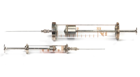Two old syringes on white with shadowの写真素材