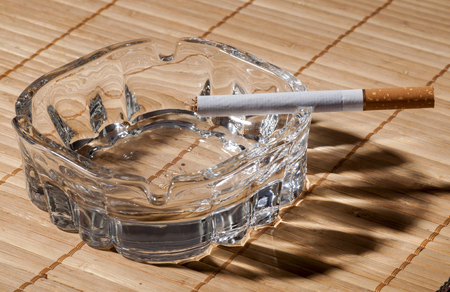 Tobacco in cigarettes with brown filter and ashtray close upの写真素材