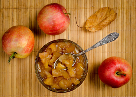 Apples and apple jam in a vase with a spoon top viewの写真素材