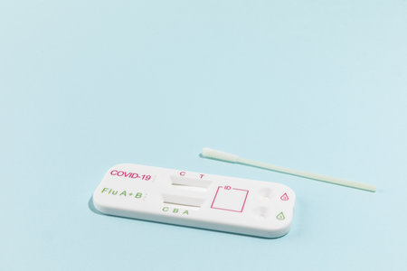 Close up image of Rapid test kit device for Covid-19 on blue surface