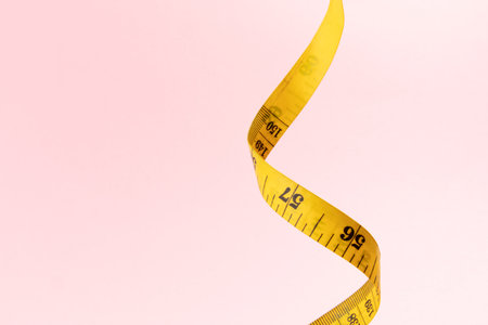 Yellow measuring tape on pink