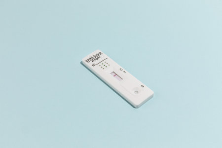 Close up image of Rapid test kit device for Covid-19 on blue surfaceの写真素材