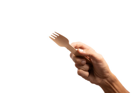 Black male hand holding a disposable wooden fork isolated no backgroundの写真素材