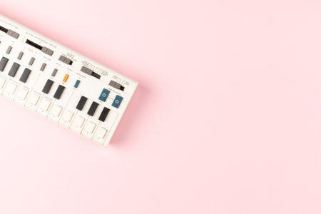 Vintage electronic keyboard synth piano on pink backgroundの写真素材
