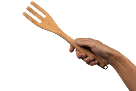 Hand holding wooden fork on white background cutoutの写真素材