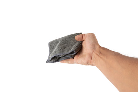 Male hand holding a cleaning cloth or dust rag isolated on white background