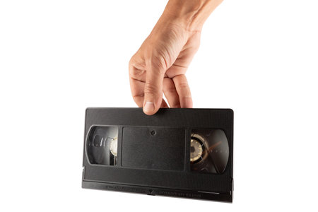 Male hand holding an VHS tape isolated no background cutout
