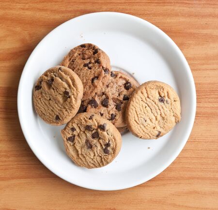 chocolate chips cookies in a dish on  the wood teble.