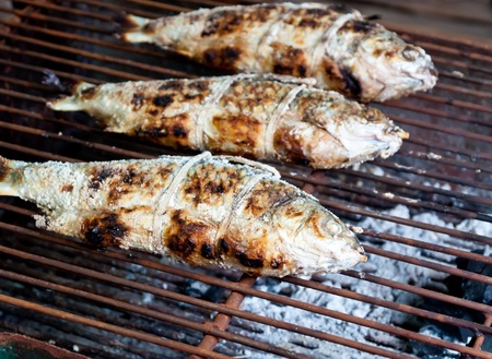 Grilling fish on grilling sticks 
