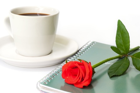 Red rose on the  notebook  with a cup of coffee.の写真素材
