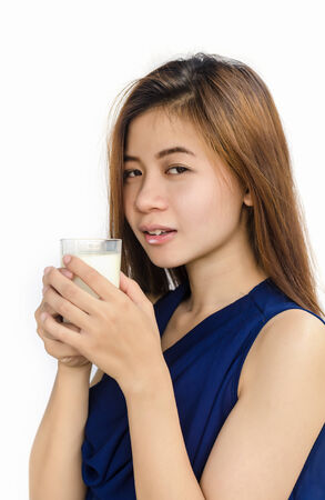 Healthy asian woman drink a glass of milk on white background の写真素材