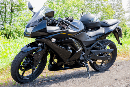 Black motobike parked on the roadsideの写真素材