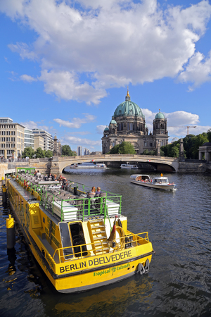 BERLIN, GERMANY - JULY 26, 2015: Exterior view of buildings and a boat shipping at the river Spree in Berlin on July 26, 2015 - Germany. The Spree is a river that flows through Berlin.のeditorial素材