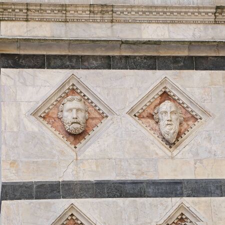 Siena - Head carved in marble on the facade of the Baptisteryの写真素材