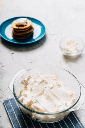 Bowl of cream cheese homemade in glass plate with pancakes and cottage cheese verticalの写真素材