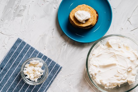 Bowl of cream cheese homemade in glass plate with pancakes and cottage cheese top viewの写真素材