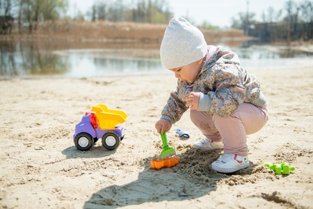 Family day in the park. Happy young couple with newborn baby. Mother carry baby in ergonomic baby carrierの写真素材