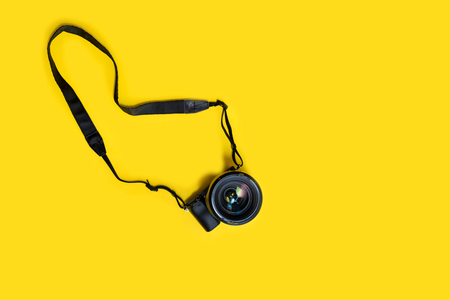 Mirrorless black camera on yellow background, summer memmories photograher blog