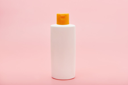 blank white squeeze bottle plastic tube on pink background copy spaceの写真素材