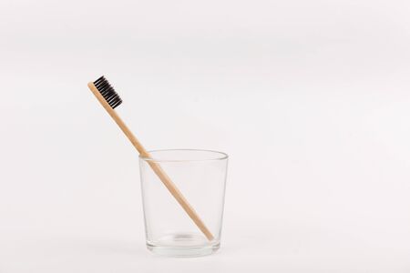 Bamboo toothbrush in glass on white background. Concept eco-friendly, no plastic, zero waste lifeの写真素材