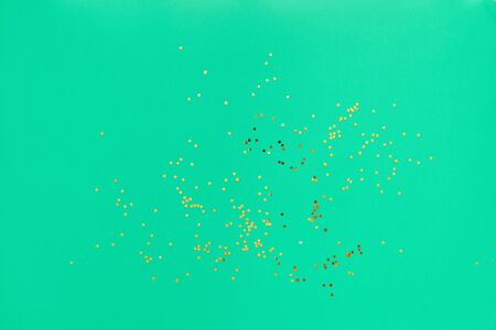 Golden glitter stars on green background flat lay. background for christmas or new year. Trendyの写真素材