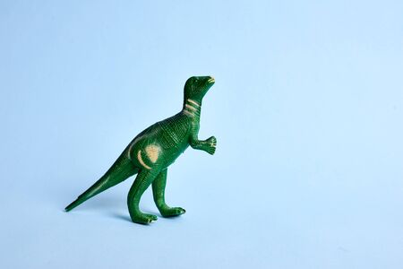 Tyrannosaur green toy. Isolated on blue background. Copy spaceの写真素材