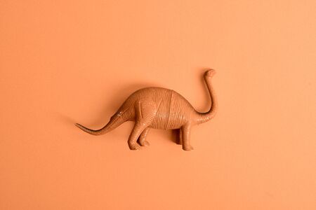 Dinosaur tyrannosaurus-rex on a yellow background. Top view. Minimalism. Copy spaceの写真素材
