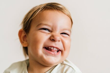 Excited face of a small baby toddler on white background. Pure joy. Close up portrait