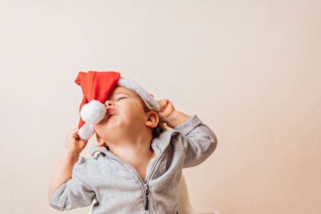funny baby girl in Santa hat having fun at home. copy space
