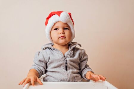 baby in Christmas bonnet dressing up the doll , on white background. copy spaceの写真素材