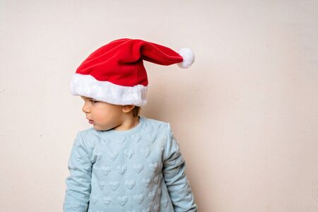 Funny little kid in red hat Santa. Christmas concept. Dancing happily.の写真素材