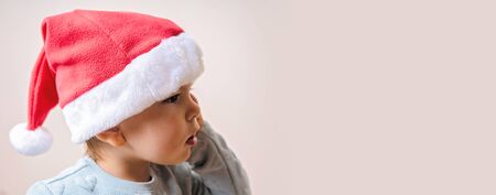Funny little kid in red hat Santa. Christmas concept. Dancing happily.の写真素材