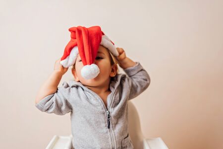 funny baby girl in Santa hat having fun at home. copy spaceの写真素材