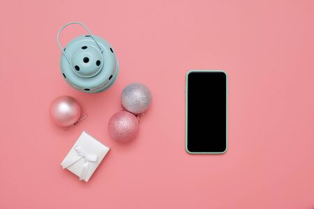 Top view of pink christmas balls and mint lamp on pink background. New year holidays. Copy space