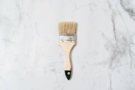 Paint tool brush top view on marble background. Minimal concept of renovation or crafts