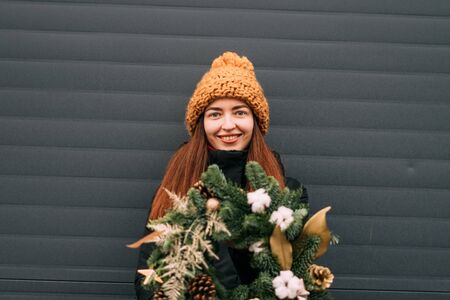 Lifestyle portrait of smiling millennial girl in orange hat. Snowy christmas dayの写真素材