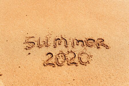 2020 summer lettering on the beach with wave and clear blue sea. Travelling on summer vacationの写真素材